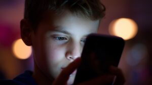 Πότε η χρήση των social media γίνεται επιβαρυντική για τον έφηβο; Σημάδια που πρέπει να προσέξουν οι γονείς a picture with an adolescent using social media, in a bright background